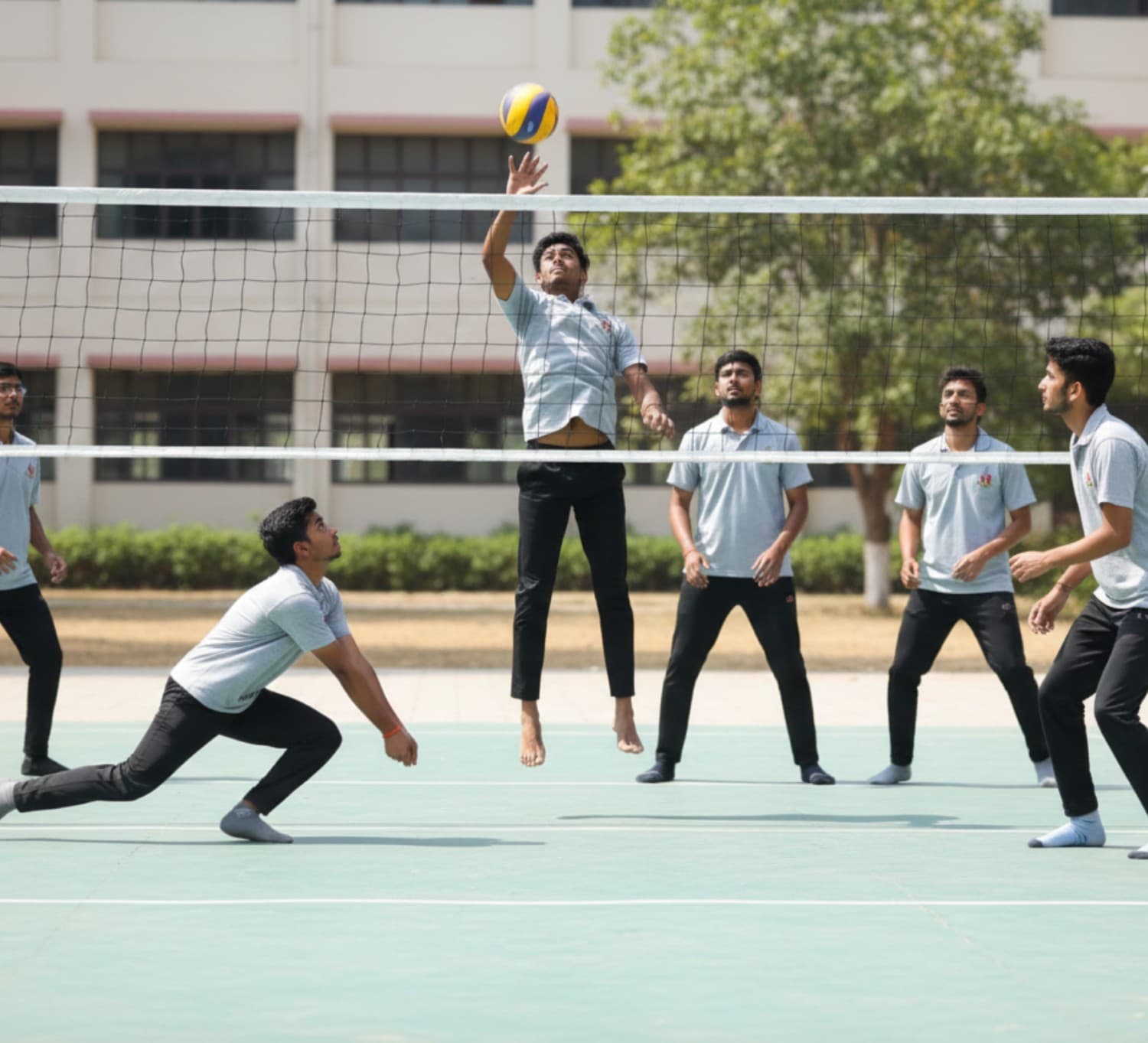 Students playing volleyball on the outdoor court at Bapuji SPSS PU College